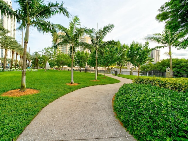 view of home's community with a yard and fence