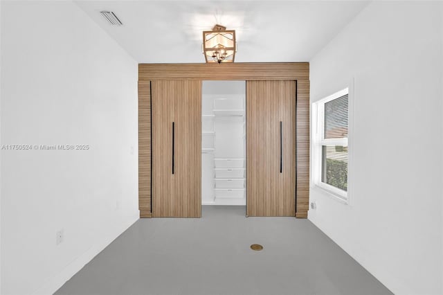 unfurnished bedroom featuring a closet, visible vents, and an inviting chandelier