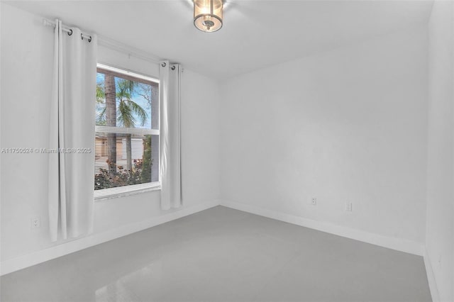 empty room with finished concrete floors and baseboards