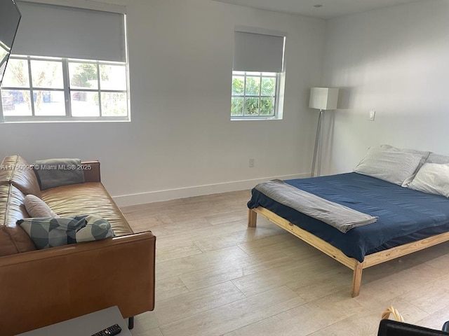 bedroom with light wood-style floors and baseboards