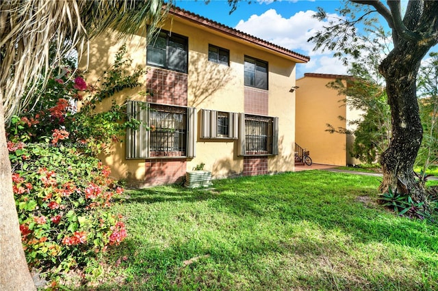 view of side of home featuring a yard and stucco siding