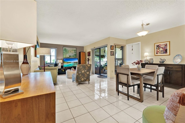 dining area with a textured ceiling and light tile patterned flooring