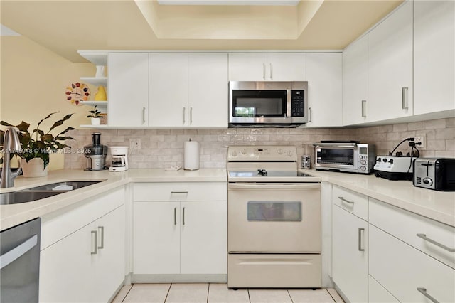 kitchen with light tile patterned flooring, a toaster, stainless steel appliances, a sink, and backsplash