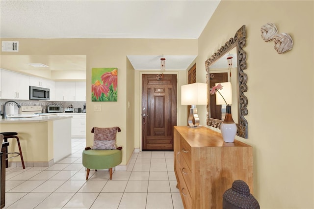 entryway featuring light tile patterned floors and visible vents