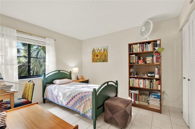 bedroom with a closet, a textured ceiling, and tile patterned floors