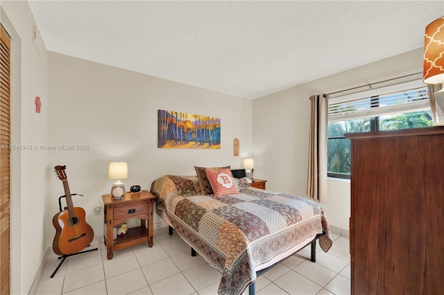 bedroom featuring a textured ceiling and light tile patterned floors