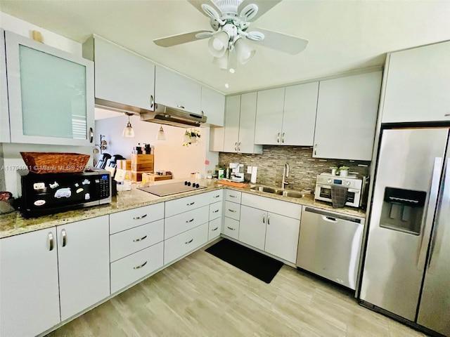 kitchen featuring stainless steel appliances, white cabinets, a sink, and tasteful backsplash