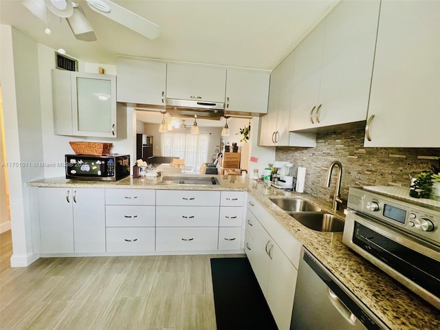 kitchen featuring stainless steel appliances, decorative backsplash, a sink, and white cabinets