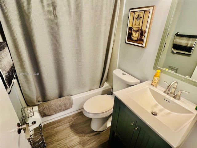 bathroom with vanity, wood finished floors, toilet, and shower / tub combo with curtain