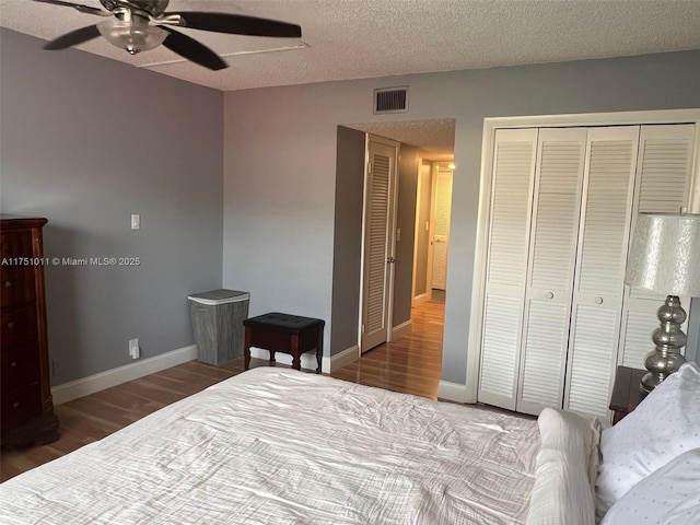 bedroom featuring dark wood-type flooring, a closet, visible vents, and baseboards