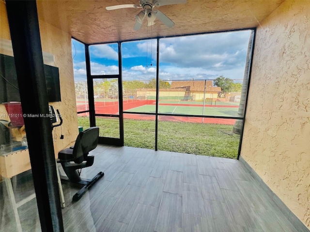 unfurnished sunroom featuring ceiling fan