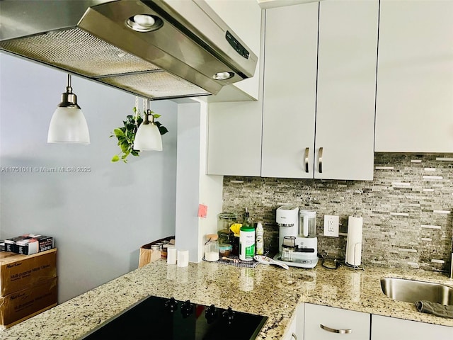 kitchen featuring white cabinetry, decorative backsplash, light stone counters, and exhaust hood