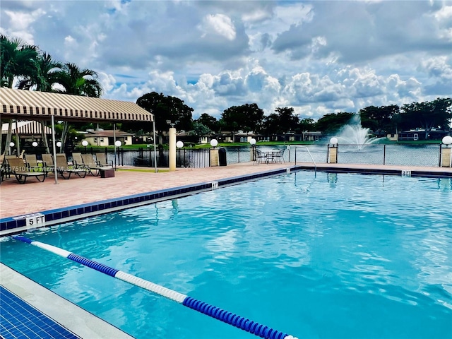 pool with a water view and fence