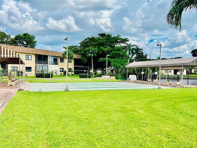 view of property's community with a yard and shuffleboard