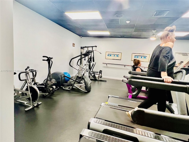 exercise room featuring baseboards, visible vents, and a drop ceiling