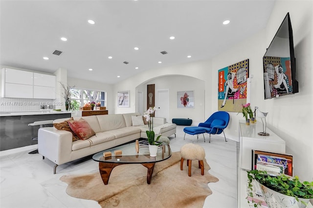 living room with recessed lighting, marble finish floor, and visible vents