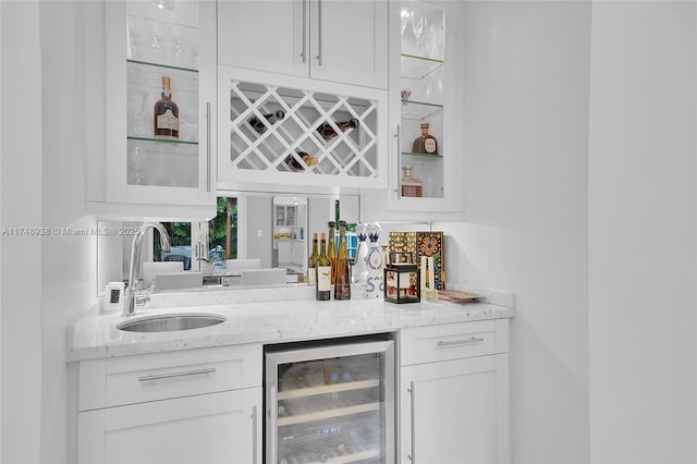 bar with beverage cooler, a sink, and a bar