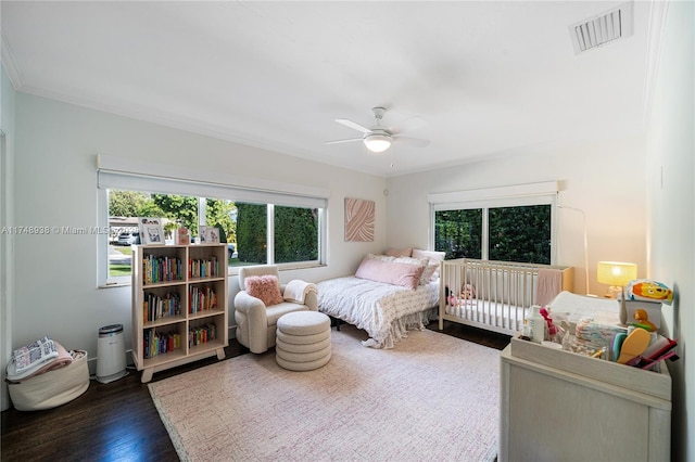 bedroom featuring a ceiling fan, crown molding, visible vents, and dark wood-style flooring