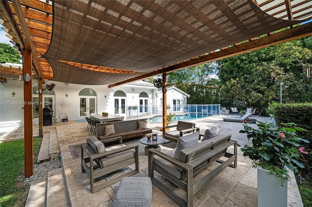 view of patio / terrace with an outdoor pool, grilling area, fence, french doors, and outdoor lounge area