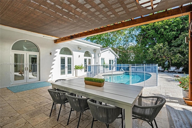 view of swimming pool featuring a patio, a fenced in pool, french doors, and outdoor dining area