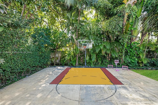 view of basketball court featuring fence and basketball court