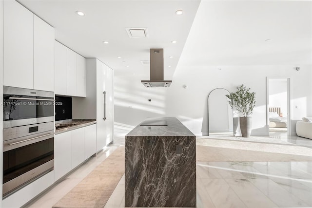 kitchen featuring dark countertops, island exhaust hood, white cabinets, and modern cabinets