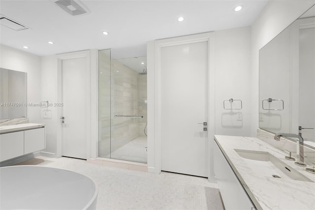 bathroom featuring a shower stall, two vanities, a sink, and recessed lighting