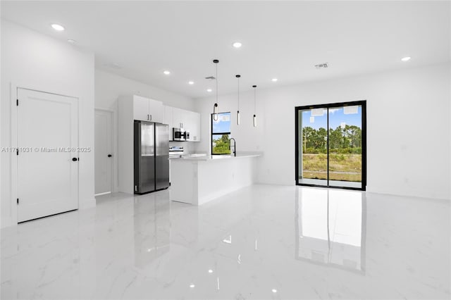 kitchen featuring stainless steel appliances, white cabinets, light countertops, marble finish floor, and pendant lighting