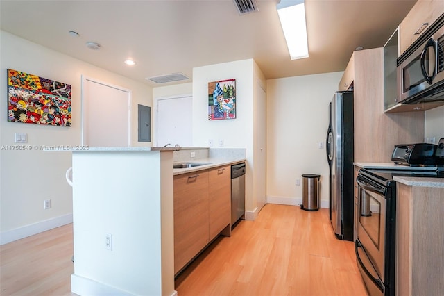 kitchen featuring stainless steel appliances, visible vents, light wood-style floors, and a peninsula