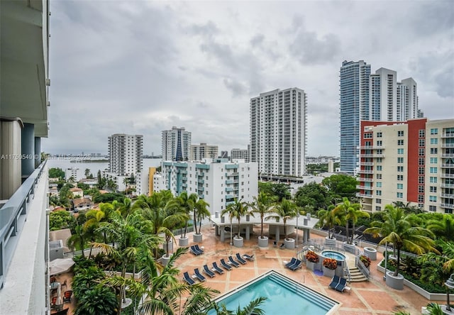 view of swimming pool with a view of city and a patio area