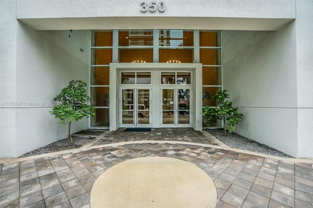 property entrance featuring french doors, a patio area, and stucco siding