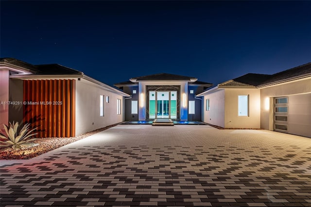 view of front of home with decorative driveway and stucco siding