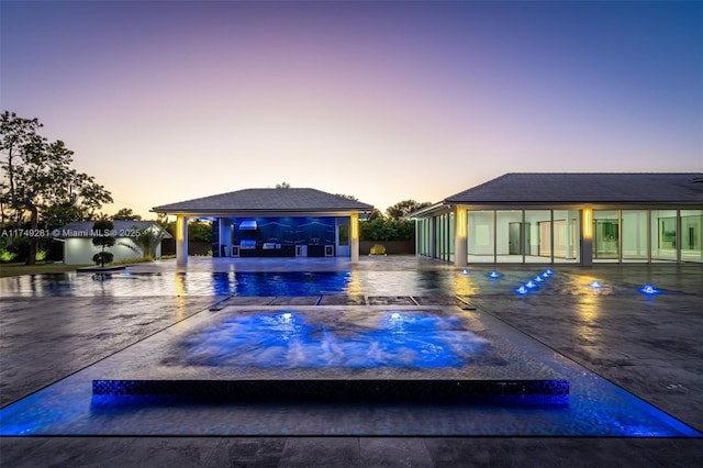 pool at dusk with a gazebo