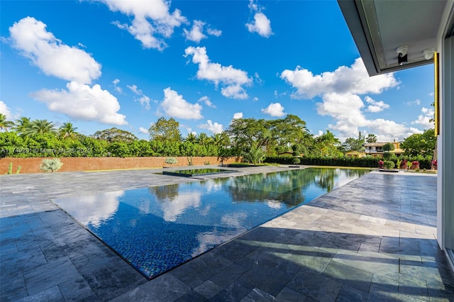 view of swimming pool with a patio area and fence