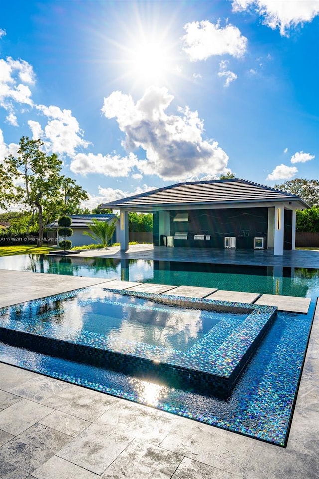 view of pool with a patio area and a pool with connected hot tub