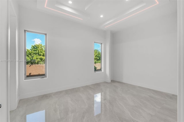 empty room with recessed lighting, a healthy amount of sunlight, and baseboards