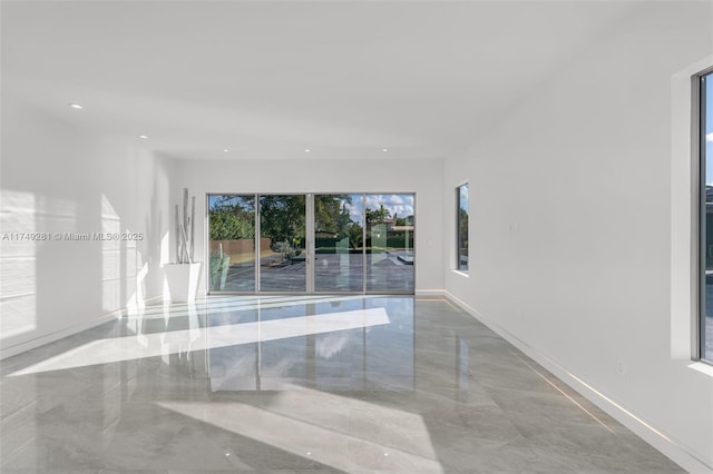 unfurnished room featuring recessed lighting, marble finish floor, and a healthy amount of sunlight