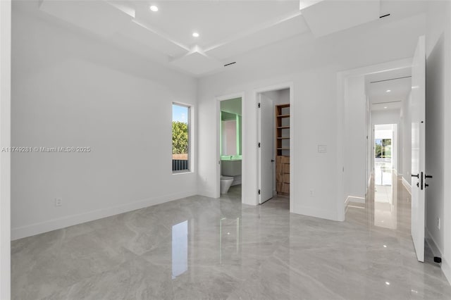 unfurnished bedroom featuring a walk in closet, baseboards, recessed lighting, marble finish floor, and ensuite bath