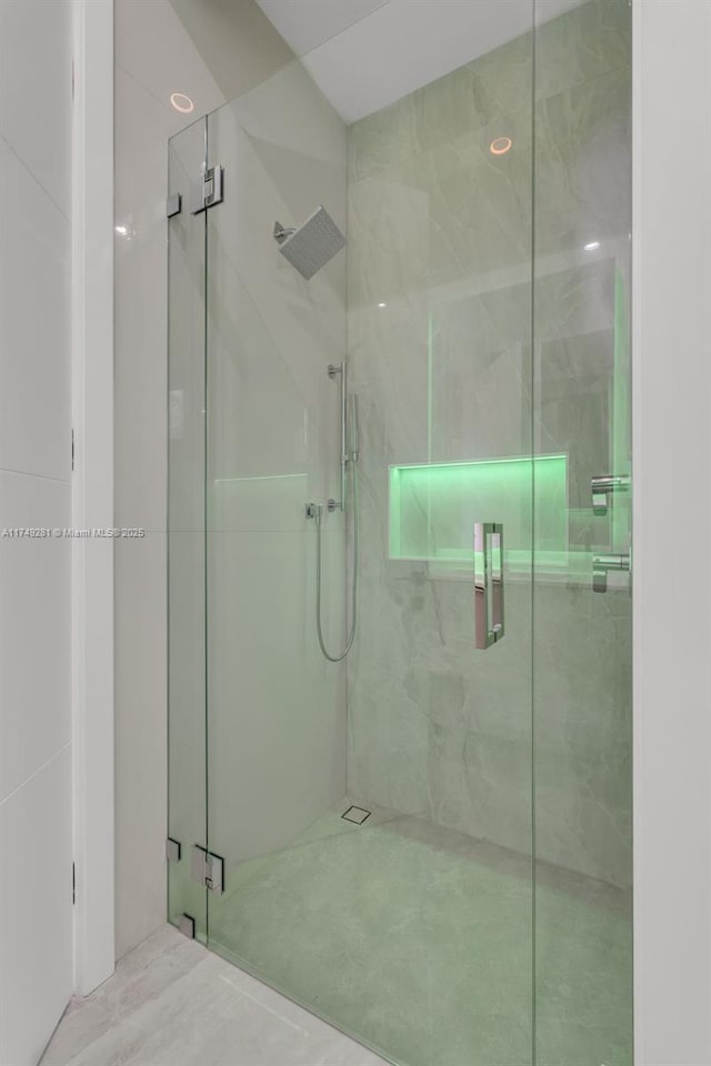 full bathroom featuring a marble finish shower