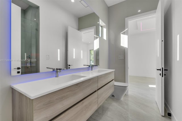 bathroom with an enclosed shower, double vanity, toilet, and a sink