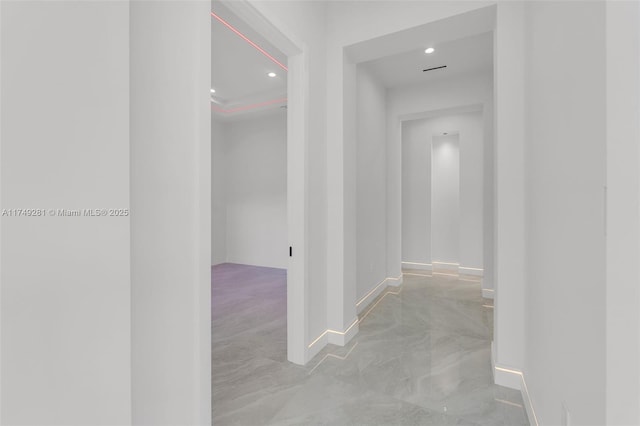 hall with recessed lighting, baseboards, and concrete floors