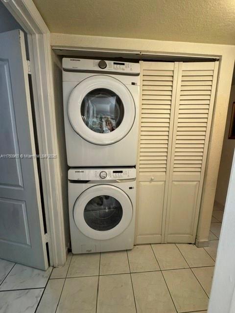 clothes washing area with stacked washer and clothes dryer