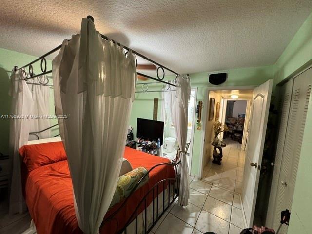 bedroom with a textured ceiling and light tile patterned flooring