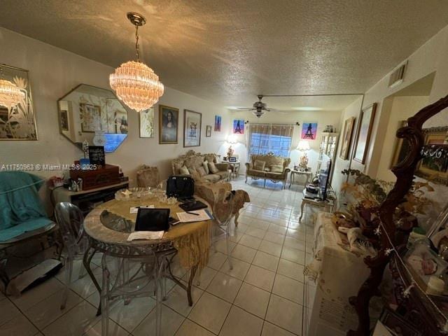 living room with light tile patterned floors, visible vents, a textured ceiling, and ceiling fan with notable chandelier