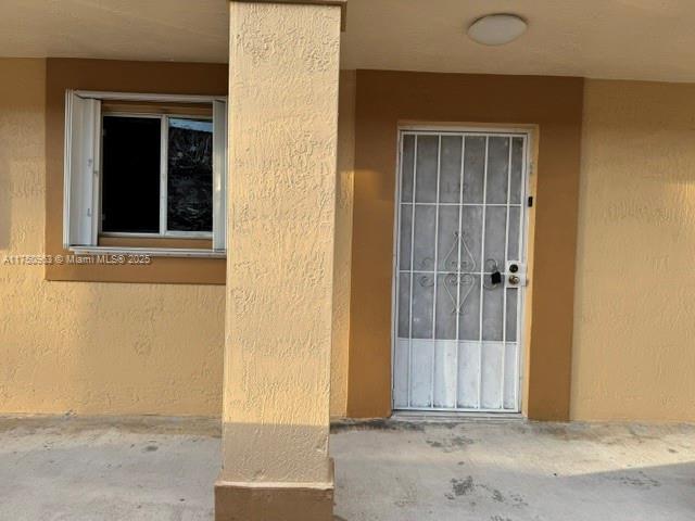 entrance to property with stucco siding