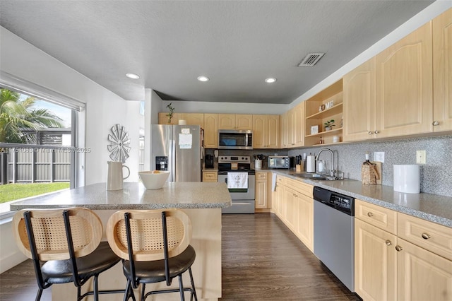 kitchen featuring visible vents, appliances with stainless steel finishes, dark wood-style flooring, light brown cabinets, and a sink