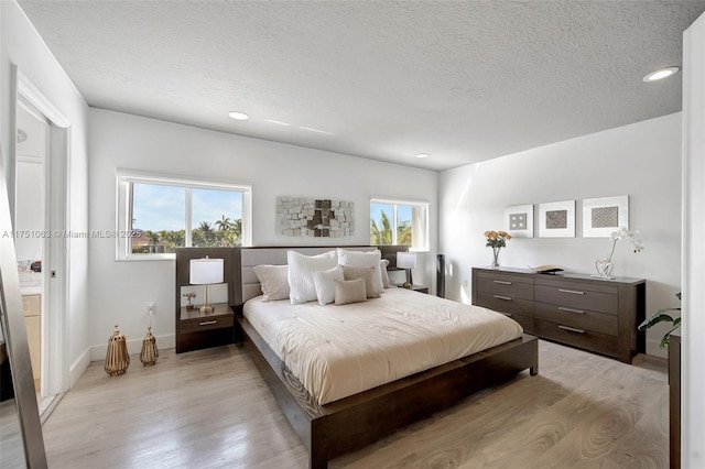 bedroom with recessed lighting, light wood-style flooring, and a textured ceiling