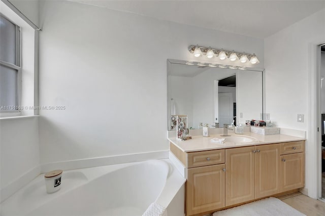 bathroom with tile patterned floors, vanity, and a bath