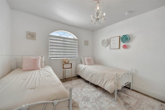 bedroom with baseboards and an inviting chandelier