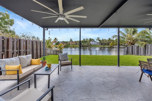 sunroom with a water view and ceiling fan